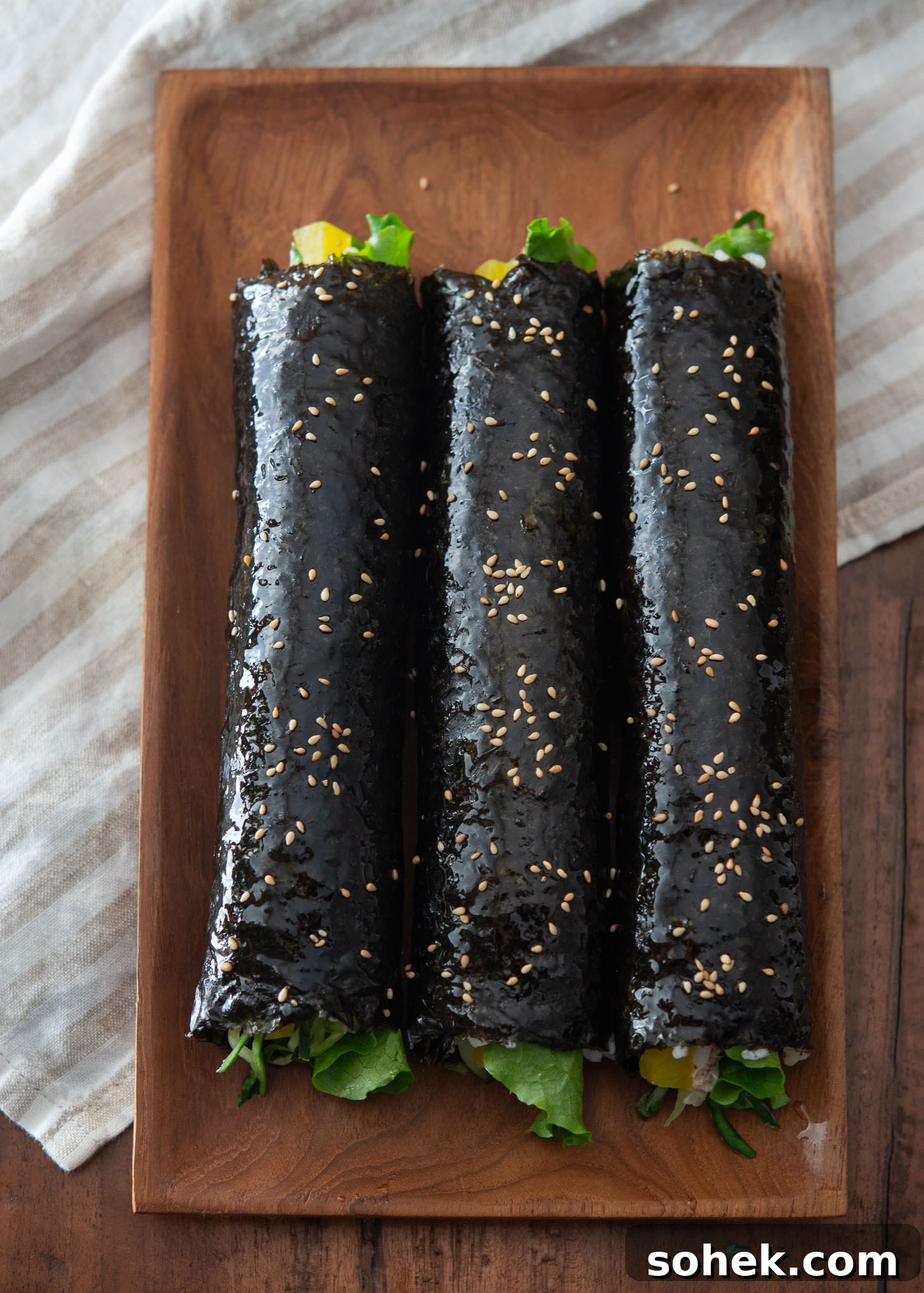 Freshly rolled tuna kimbap with sesame oil and sesame seed garnish