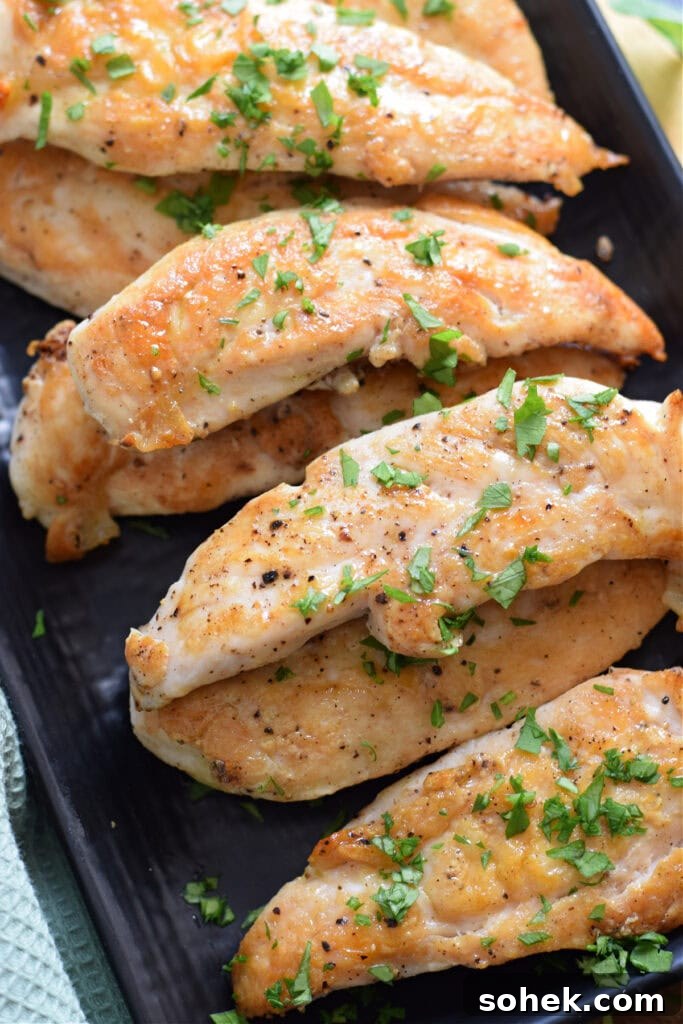 Chicken tenders on a black plate.