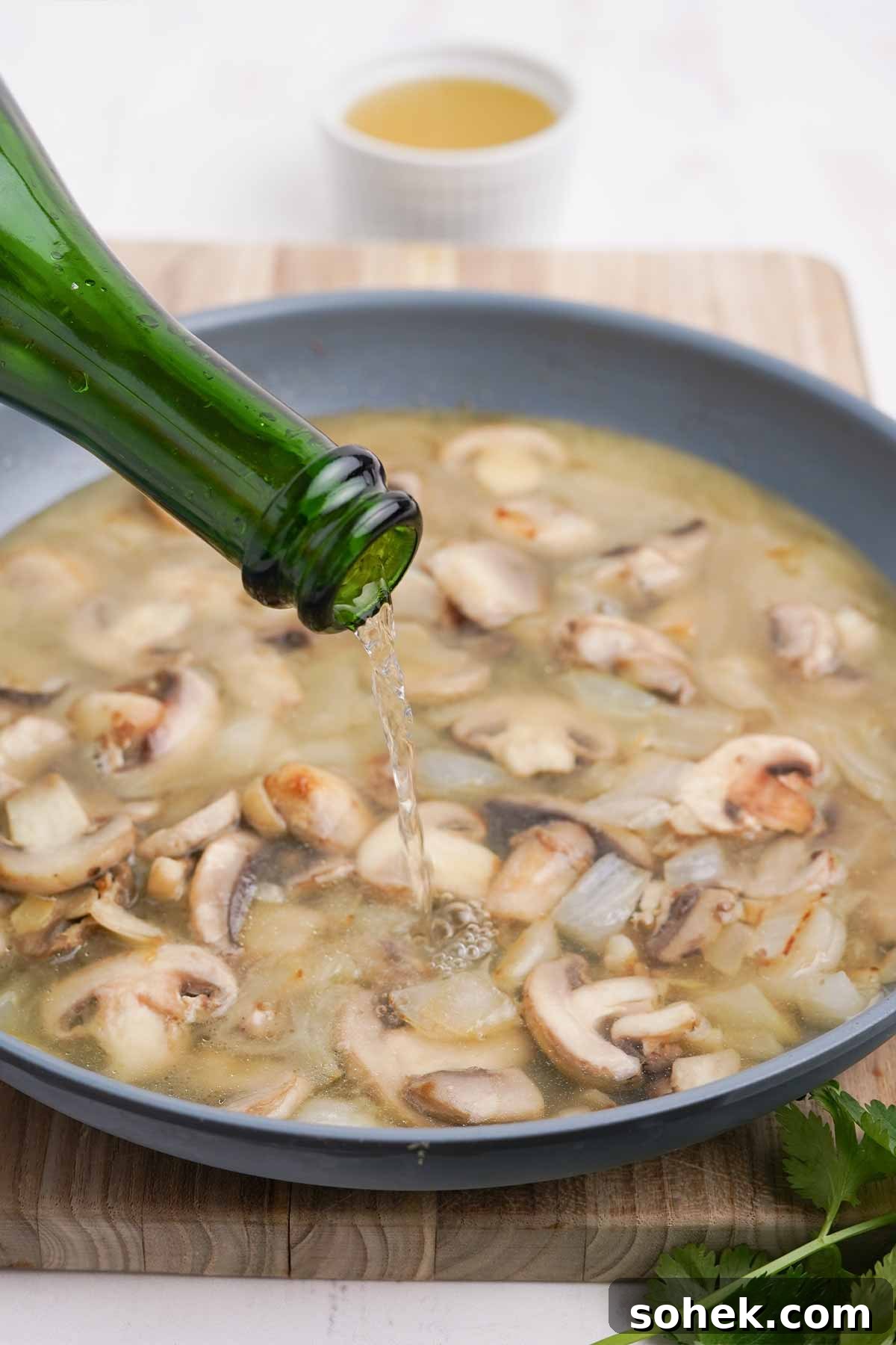 Adding the champagne to the skillet.
