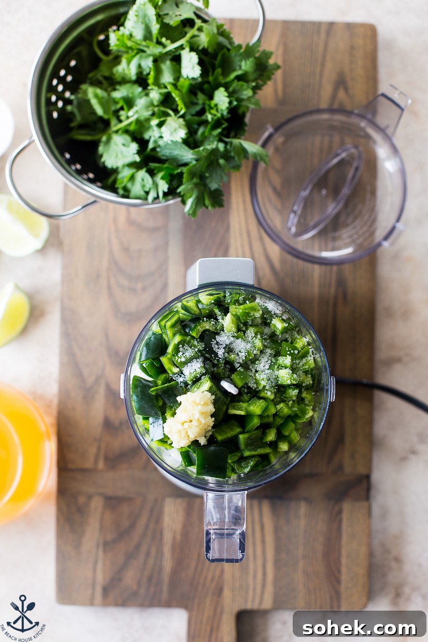 Overhead photo of a mini food processor filled with peppers and garlic