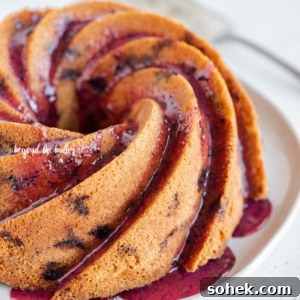 Angled image of super easy blueberry bundt cake with blueberry glaze drizzled over the top.