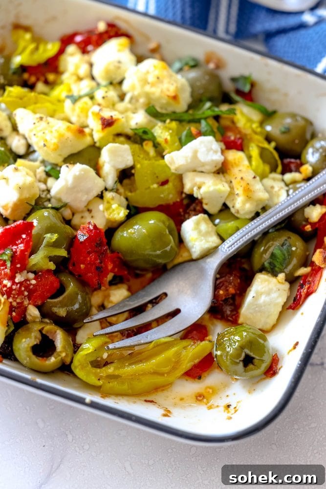 Mediterranean Baked Olives with Feta and Herbs 3 picture of baked olives and feta in a white glass dish