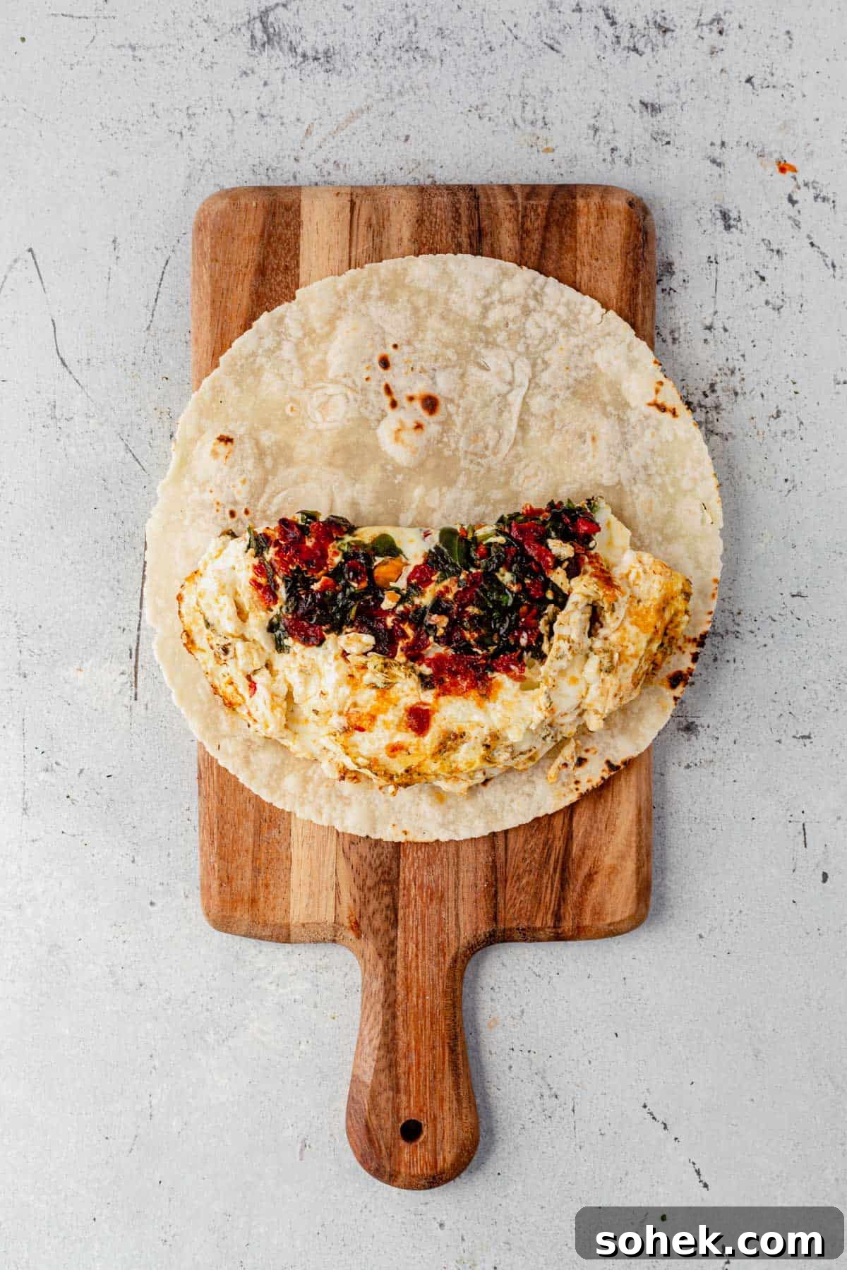 Spinach and Feta Egg White Wrap Recipe for Protein-Packed Breakfast 6 cooked egg white, spinach, and feta on a tortilla.