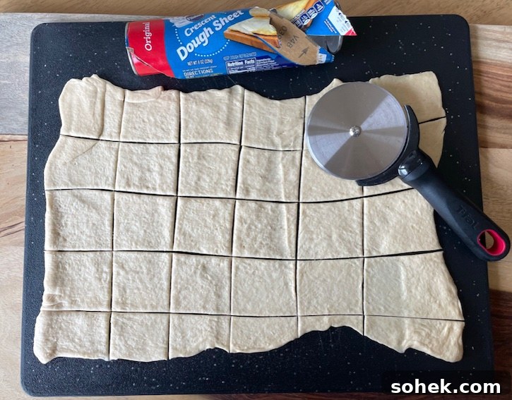 Savory Mini Meatball Cupcakes for Appetizers and Parties 5 Cutting up a Pillsbury crescent dough sheet for making muffin tin mini meatball cupcakes.