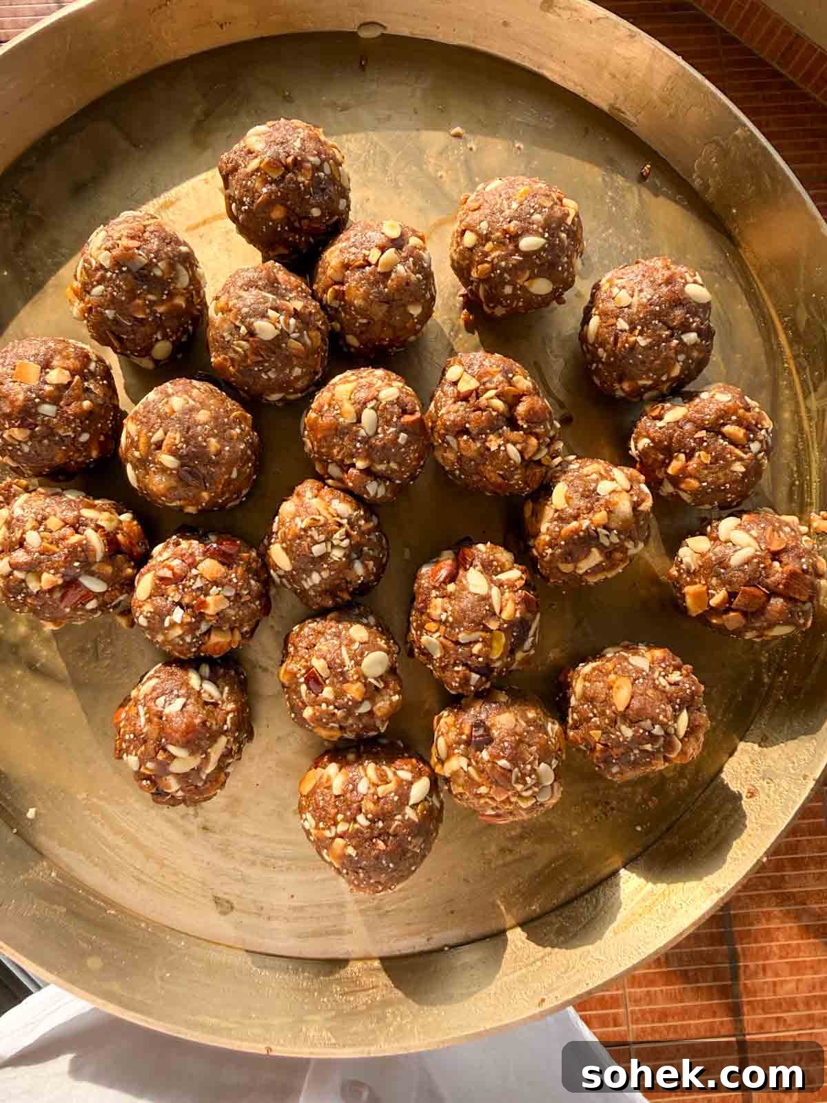 Gond Laddu (Pinni) Recipe: How to Make Traditional Dink Laddu 2 gond ke laddu served on a copper platter
