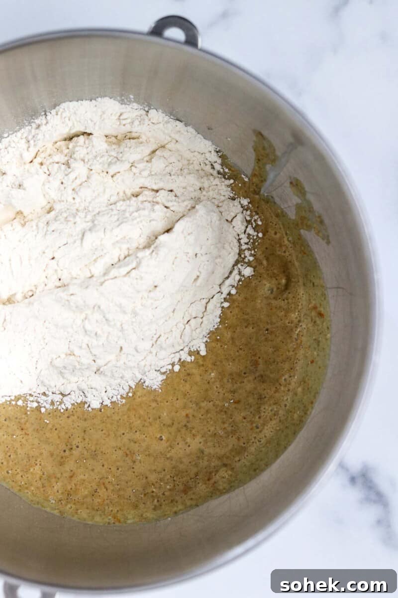 Flour and bread dough in a metal bowl.