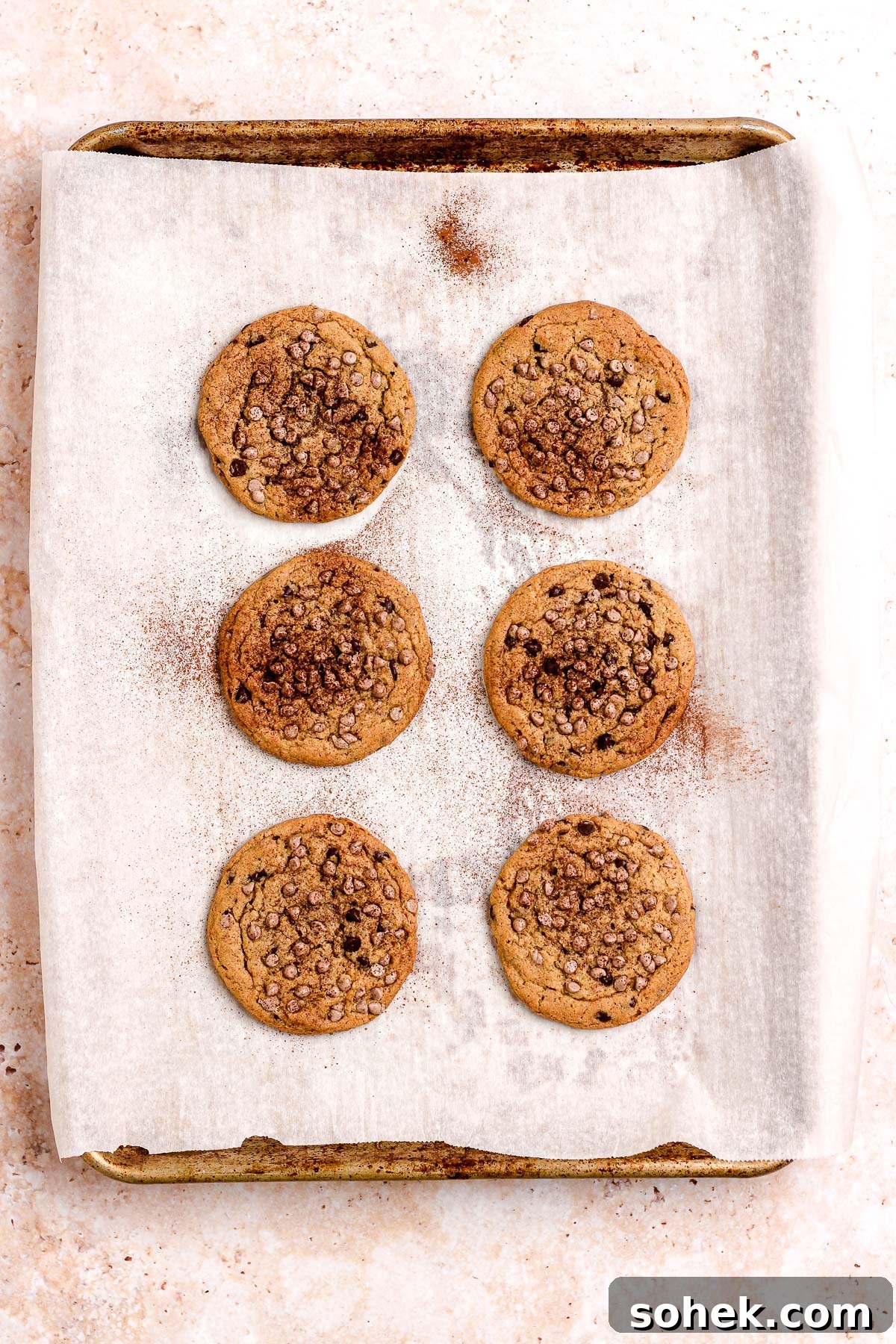 Cinnamon Chocolate Chip Cookie Recipe — Warm, Spiced Chocolate Treat 12 Cinnamon chocolate chip cookies on a parchment lined baking sheet.
