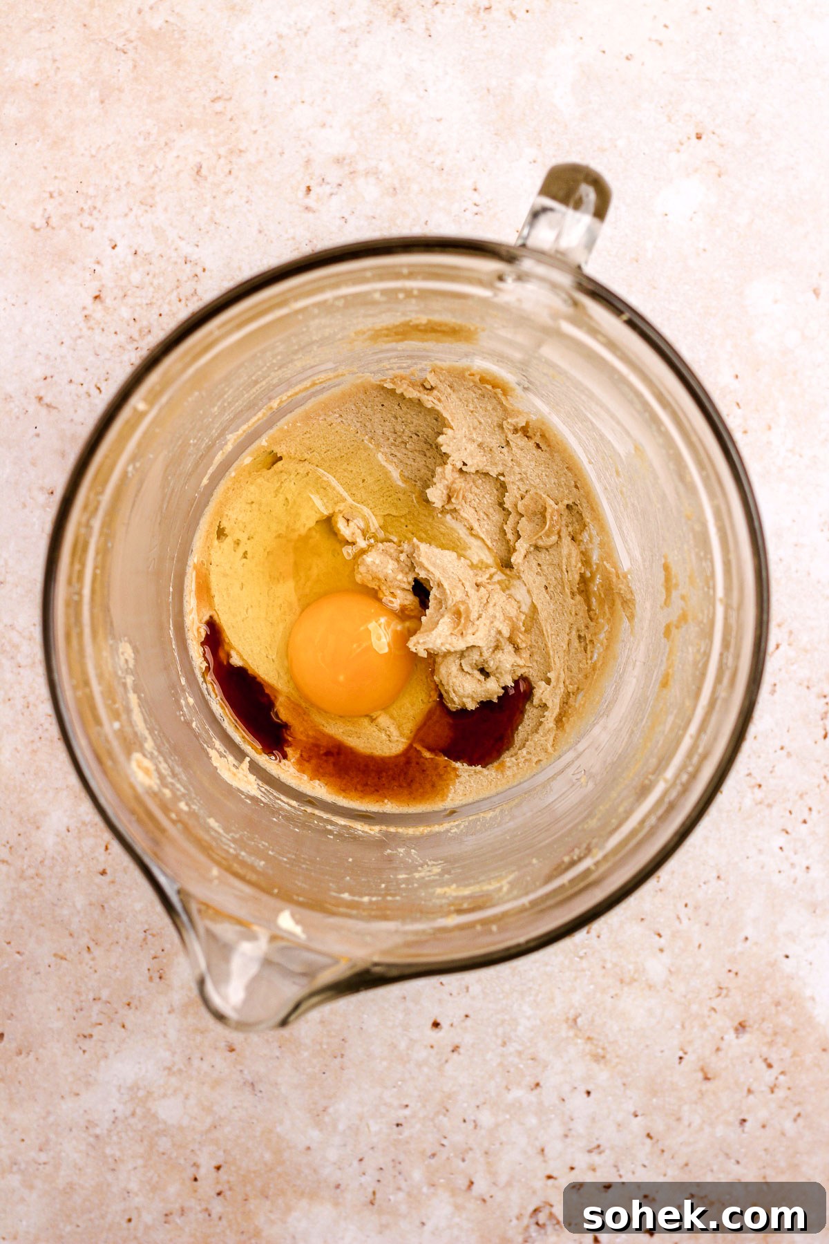 Cinnamon Chocolate Chip Cookie Recipe — Warm, Spiced Chocolate Treat 6 A glass bowl of creamed sugar and butter with an egg and vanilla for cookie dough.