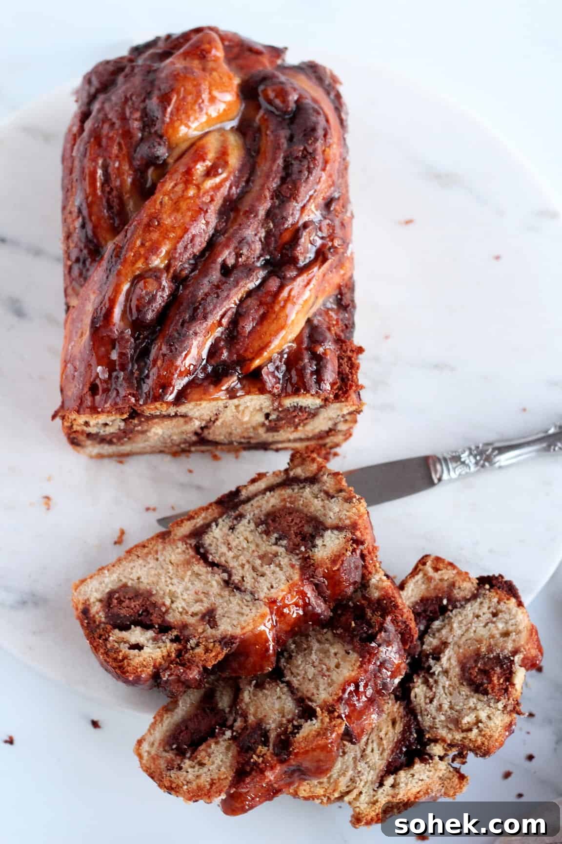 few pieces of chocolate babka with almond filling on the marble plate