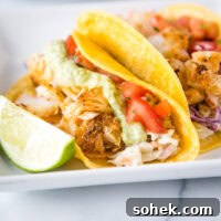 A plate of fish tacos with different toppings, with Taco