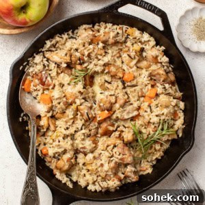 Dijon Chicken Skillet with Wild Rice and Veggies 11 A chicken and wild rice skillet with fresh herbs and vegetables on a white table.