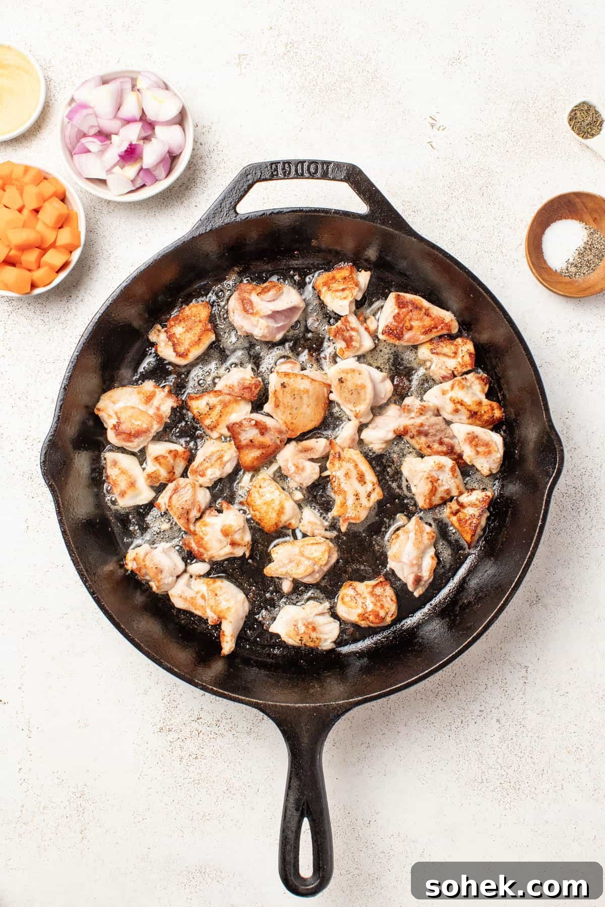 Dijon Chicken Skillet with Wild Rice and Veggies 5 Browning chicken thighs in a cast iron pan.