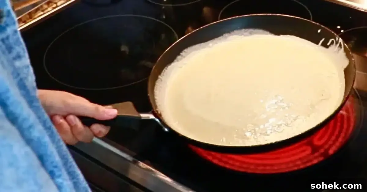Classic French Crepes: Thin Pancake Recipe & Serving Ideas 14 spread crepe batter over a hot pan