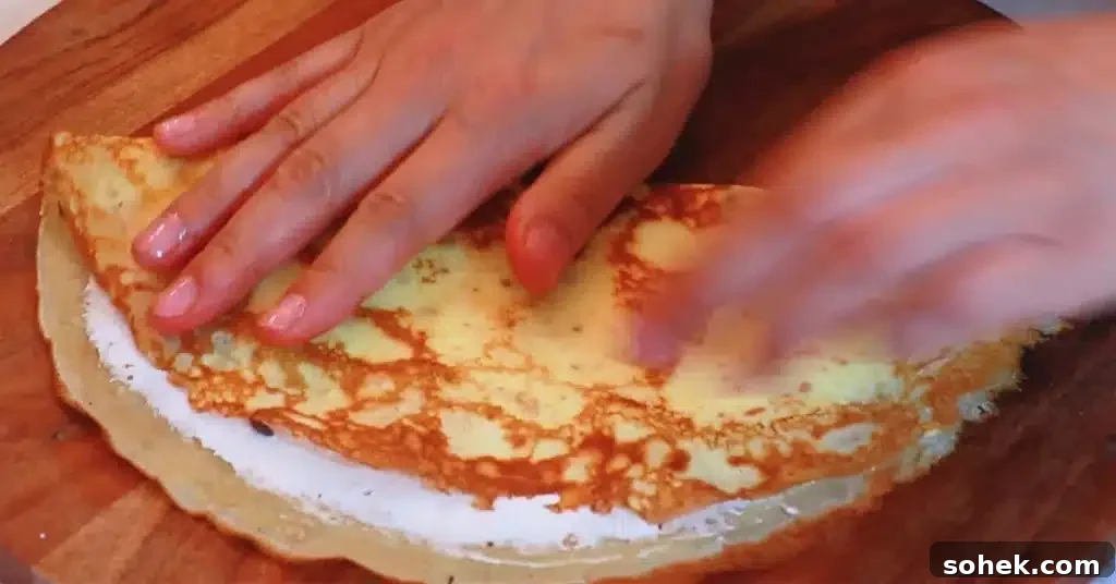 Classic French Crepes: Thin Pancake Recipe & Serving Ideas 17 folding a crepe to make a crepe dessert