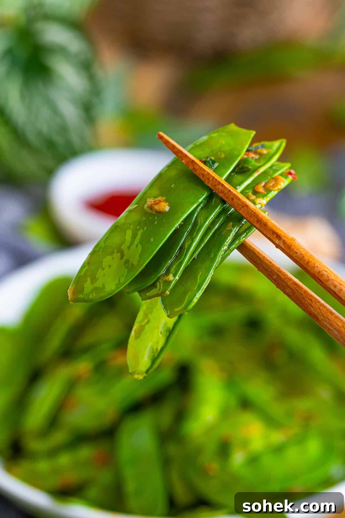 chopsticks holding snow peas recipe in air