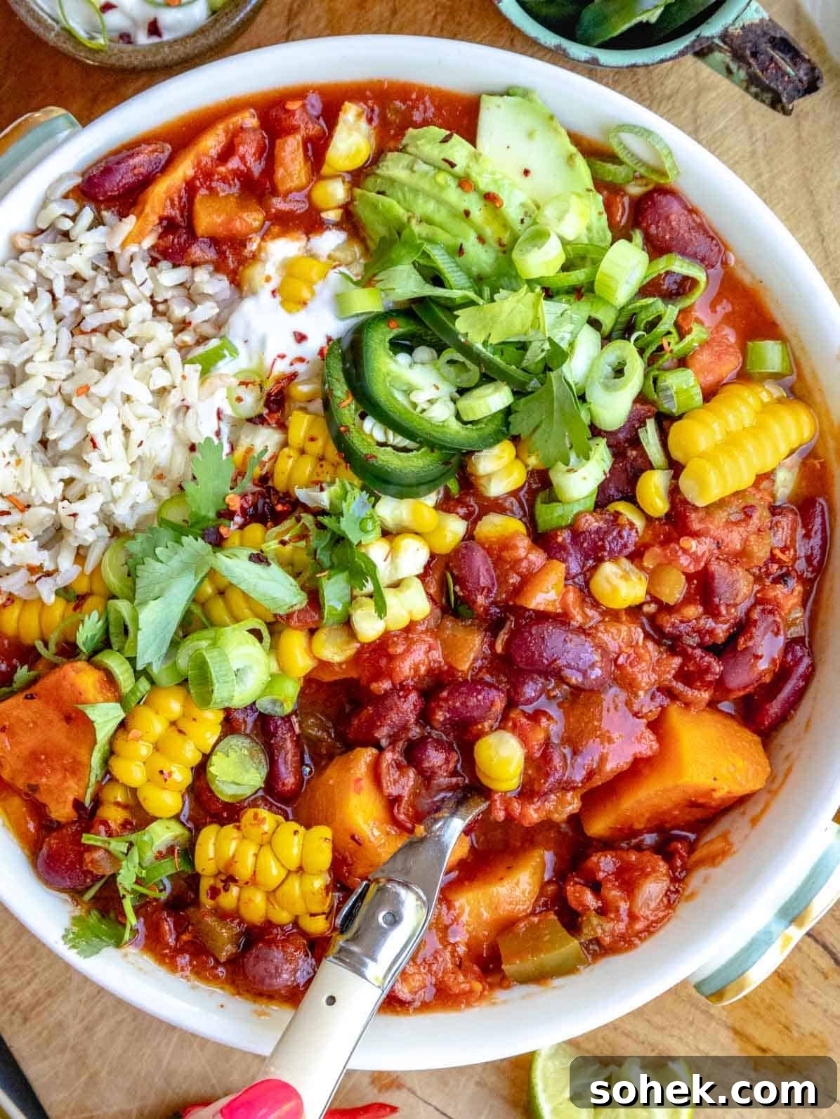 Hearty Sweet Potato Chili with Black Beans and Chipotle 2 sweet potato chili with corn, cilantro, rice and a spoon