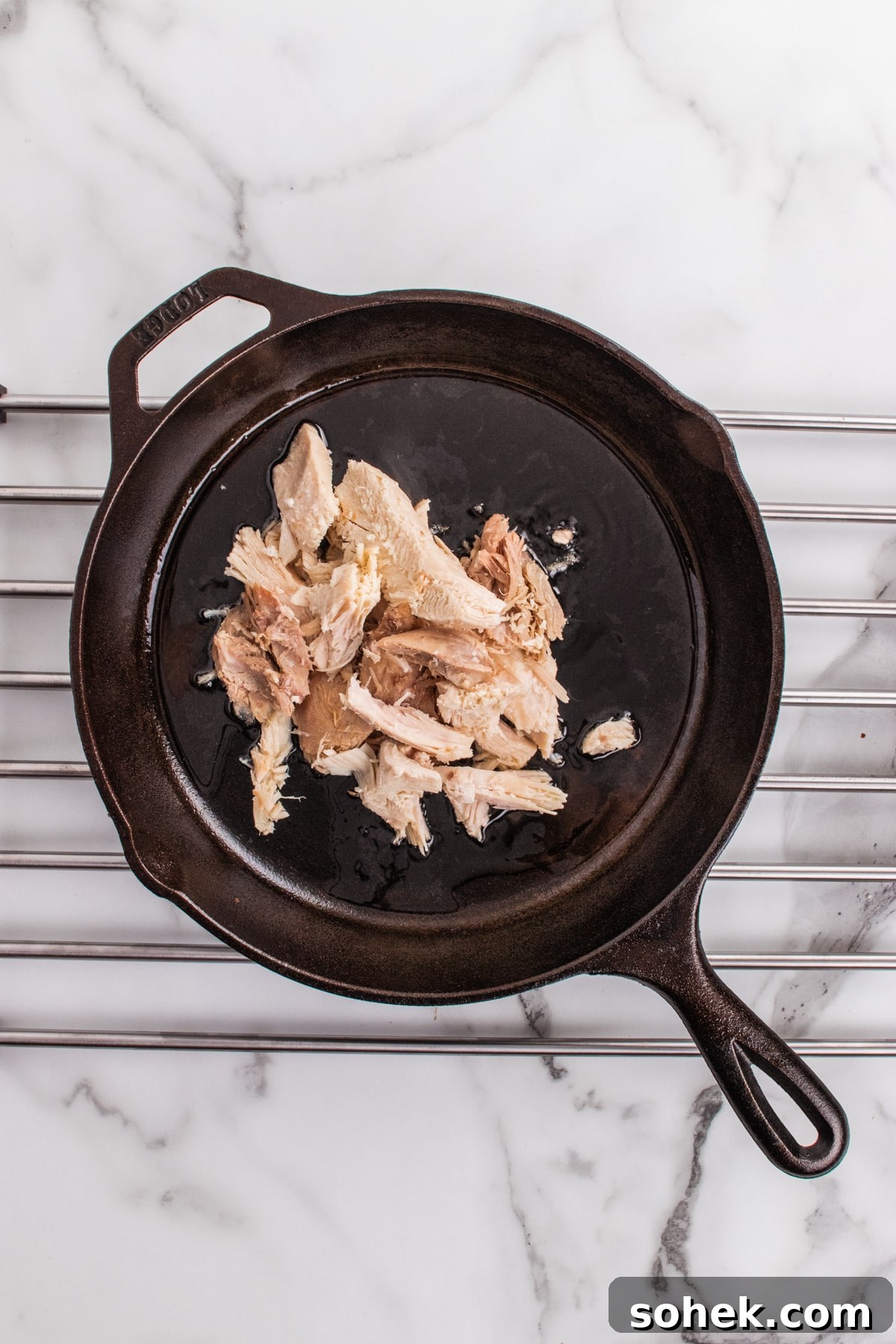 Leftover turkey shredded and in a cast iron skillet.
