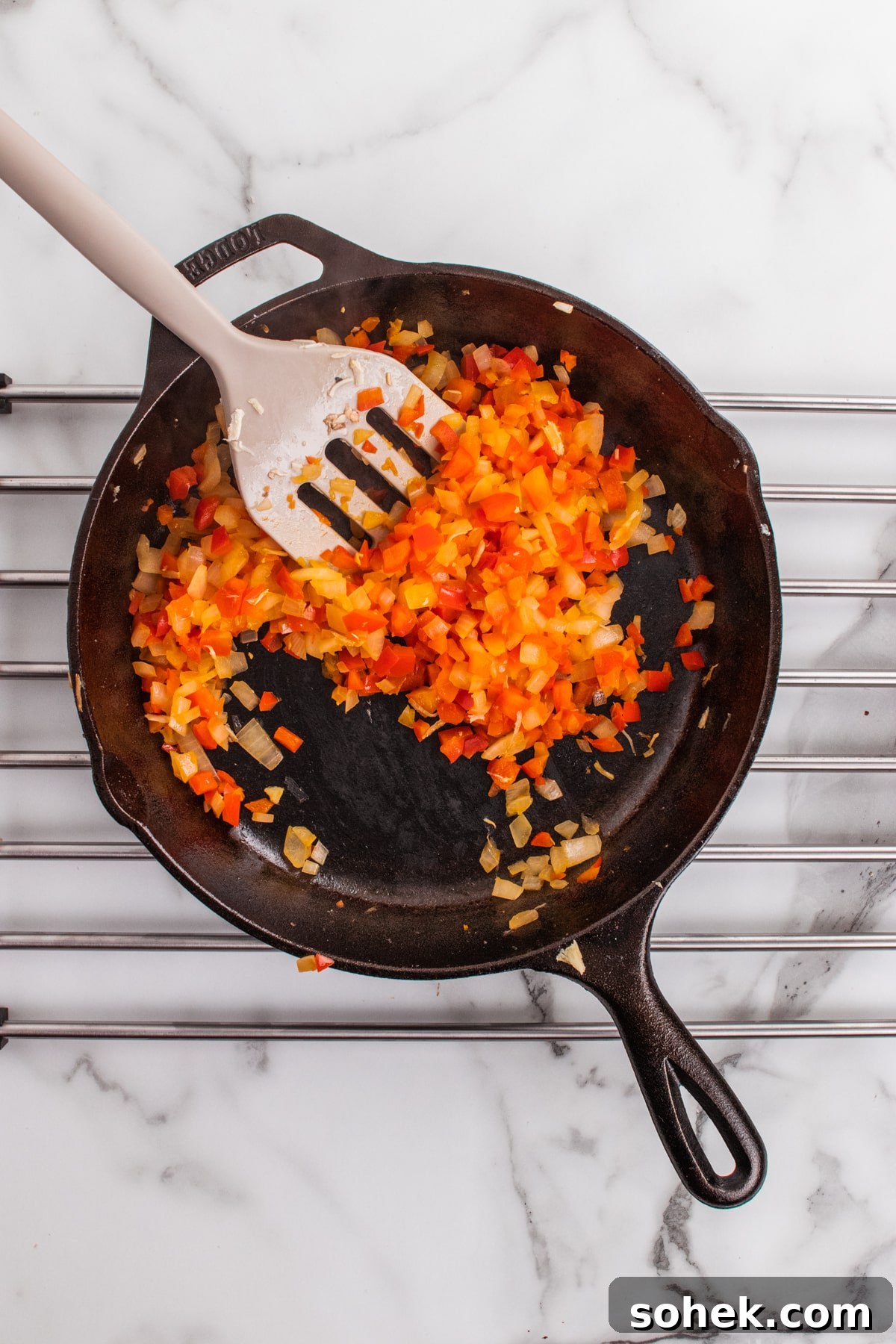 Onions and peppers sautéed in a cast iron skillet. 