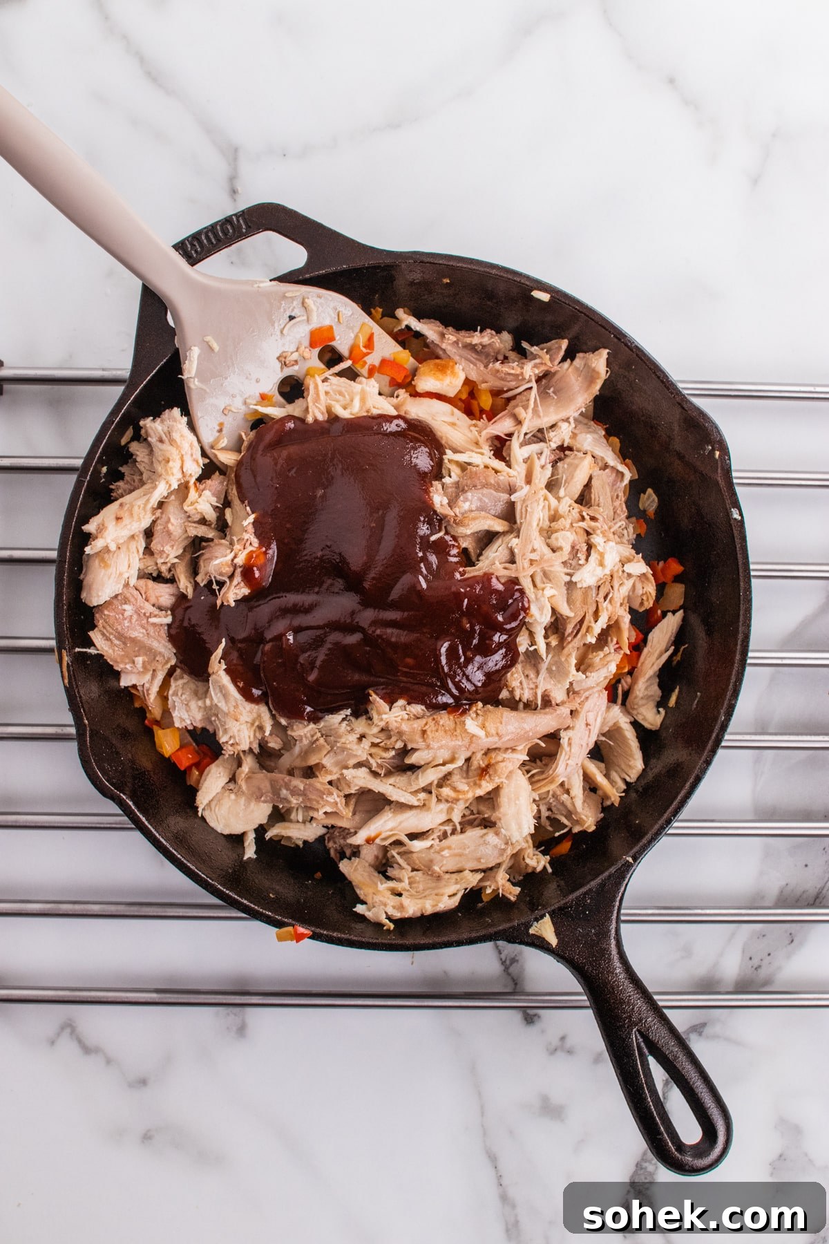 BBQ sauce added to a skillet of leftover turkey meat.