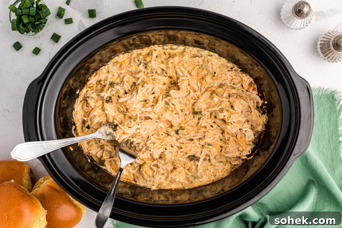 Slow Cooker Jalapeño Popper Chicken Recipe 5 jalapeno popper chicken shredded with 2 forks in it.