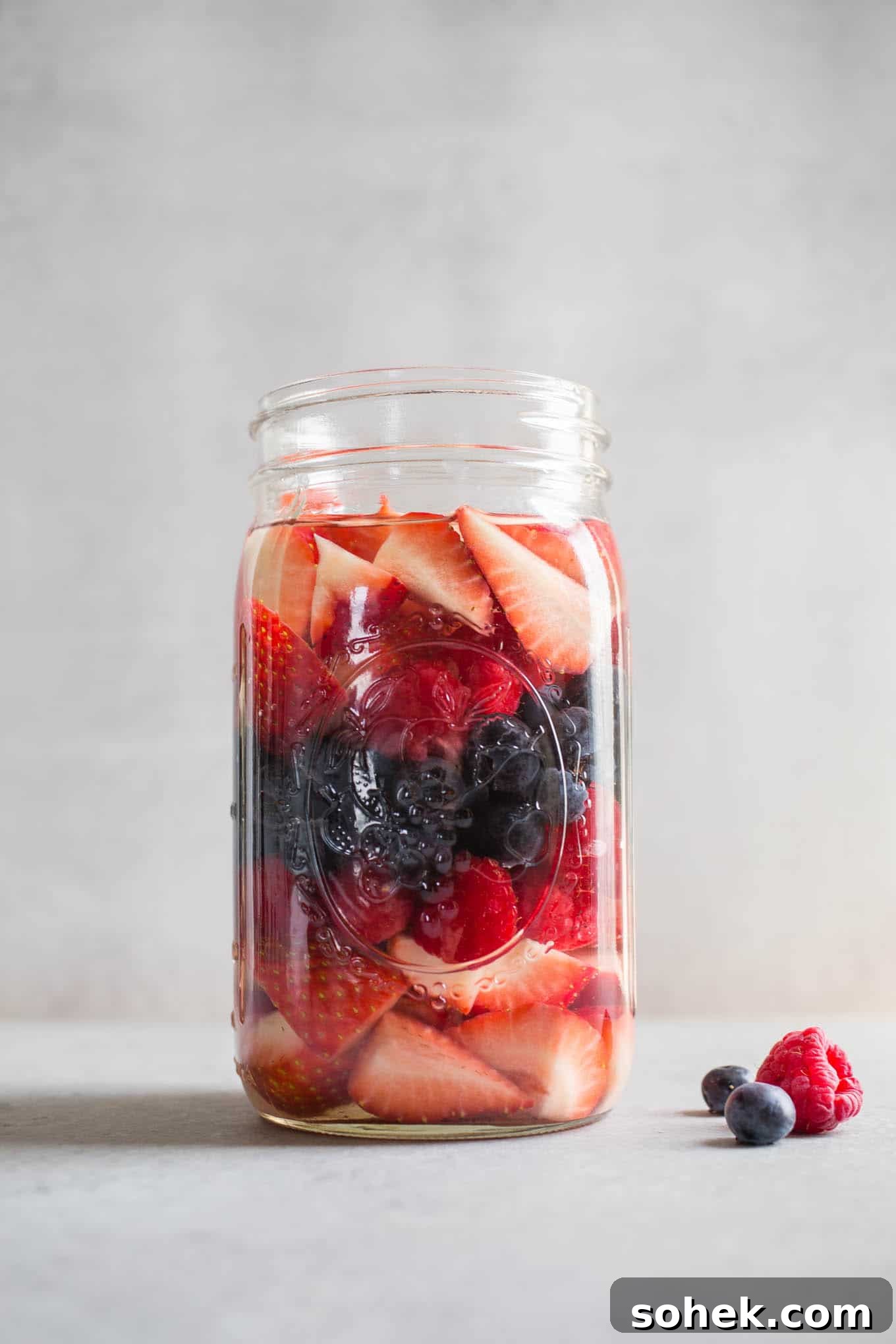 A large glass jar with berries.