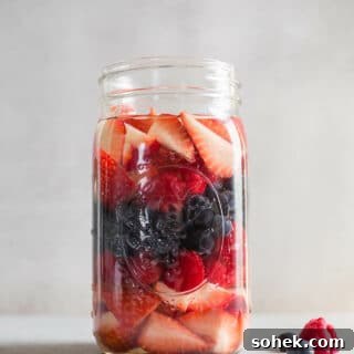 A large glass jar with berries.