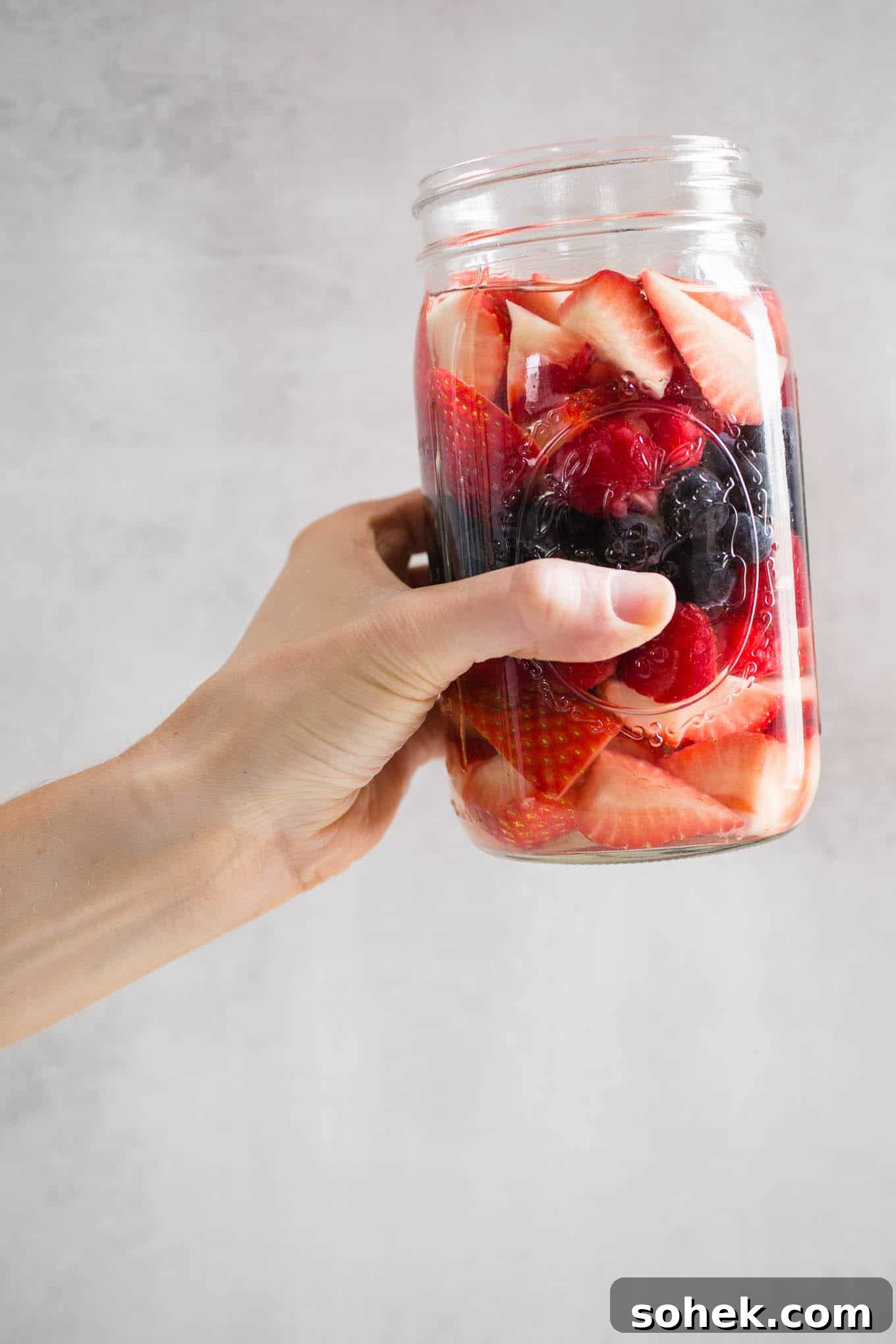 A jar of berries being held up.