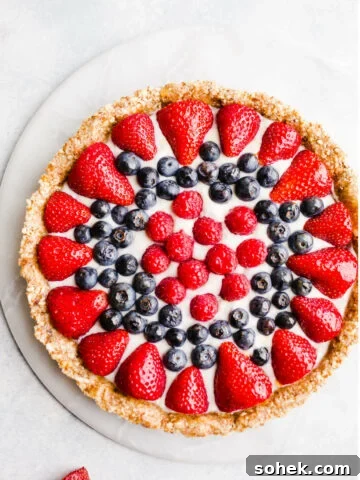 A fruit tart on a marble platter.