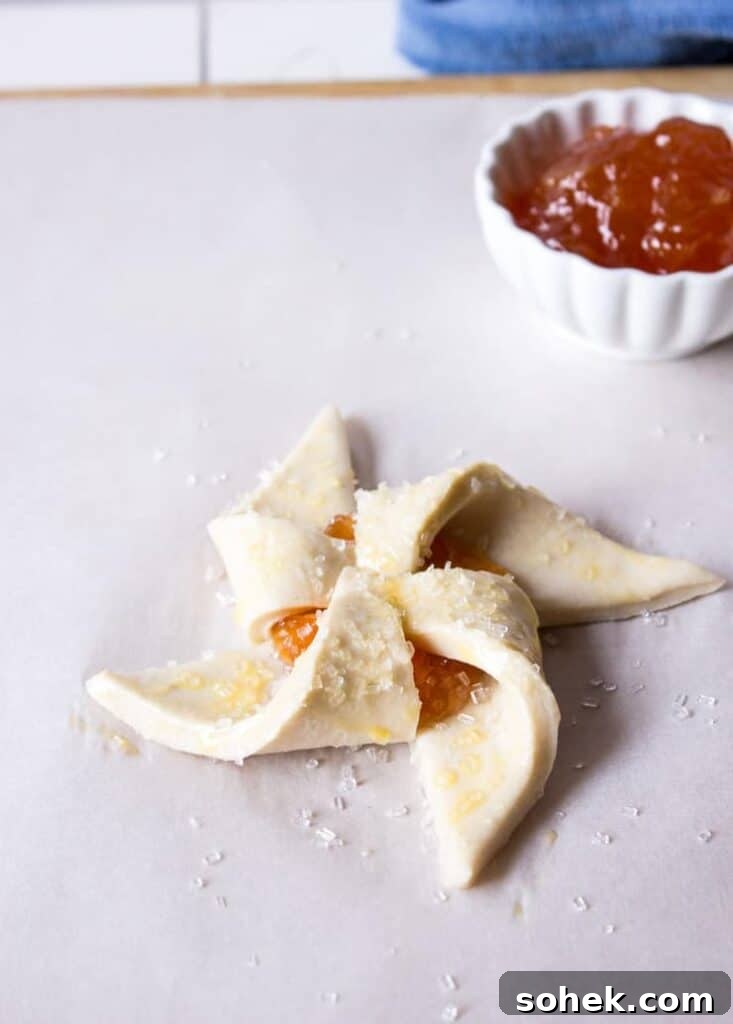 Savory and Sweet Puff Pastry Pinwheels: Quick Party Appetizers 6 An unbaked pastry with jam and a sprinkling of sugar.