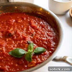 Marinara sauce in a pan garnished with basil.