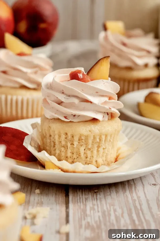 Gluten-Free Dairy-Free Peach Cupcakes: Moist Summer Dessert 6 Soft vanilla cupcakes filled with a peachy pink peach filling and topped with a fluffy light pink peach buttercream frosting swirl.