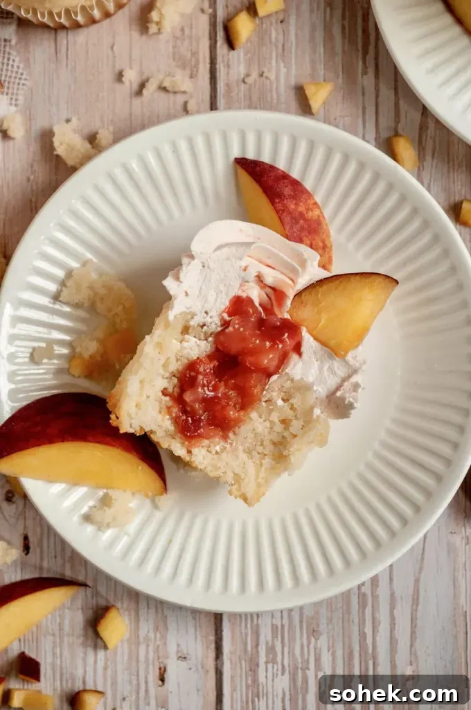 Gluten-Free Dairy-Free Peach Cupcakes: Moist Summer Dessert 7 Soft vanilla cupcakes filled with a peachy pink peach filling and topped with a fluffy light pink peach buttercream frosting swirl.
