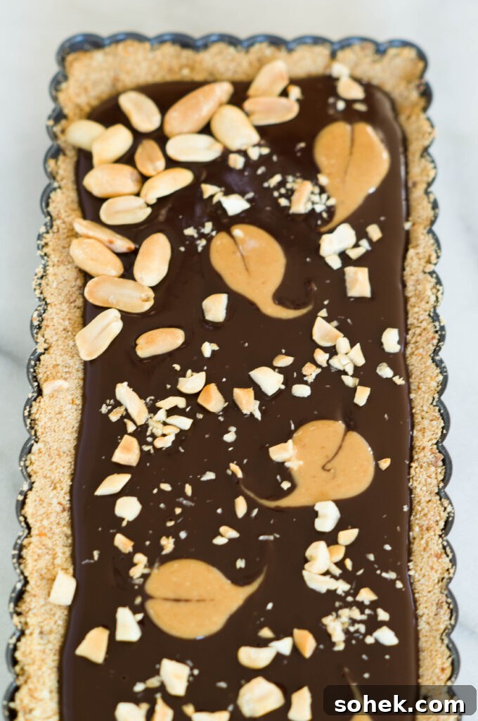 Slice of tart showing chocolate ganache and peanut butter swirl