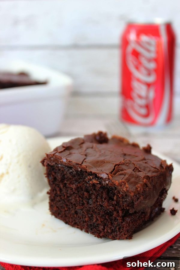 Copycat Cracker Barrel Coca-Cola Cake Recipe You’ll Love 5 a slice of chocolate cake with chocolate frosting with a coca cola can in the background.