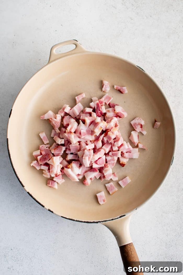 Diced guanciale cooking in a large pan.