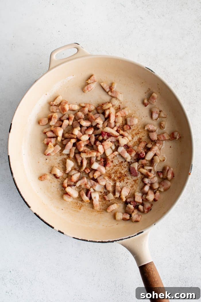 Large pan filled with crispy guanciale with fat rendered.