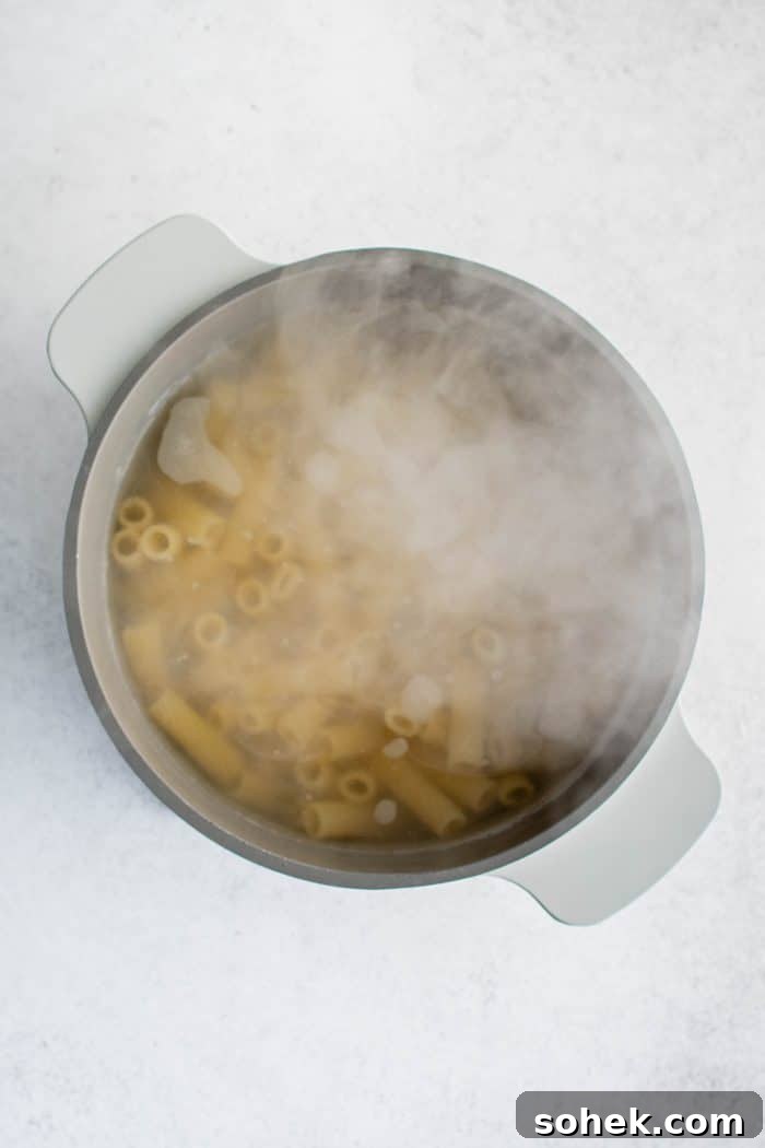 Rigatoni pasta cooking in a large pot of boiling water.