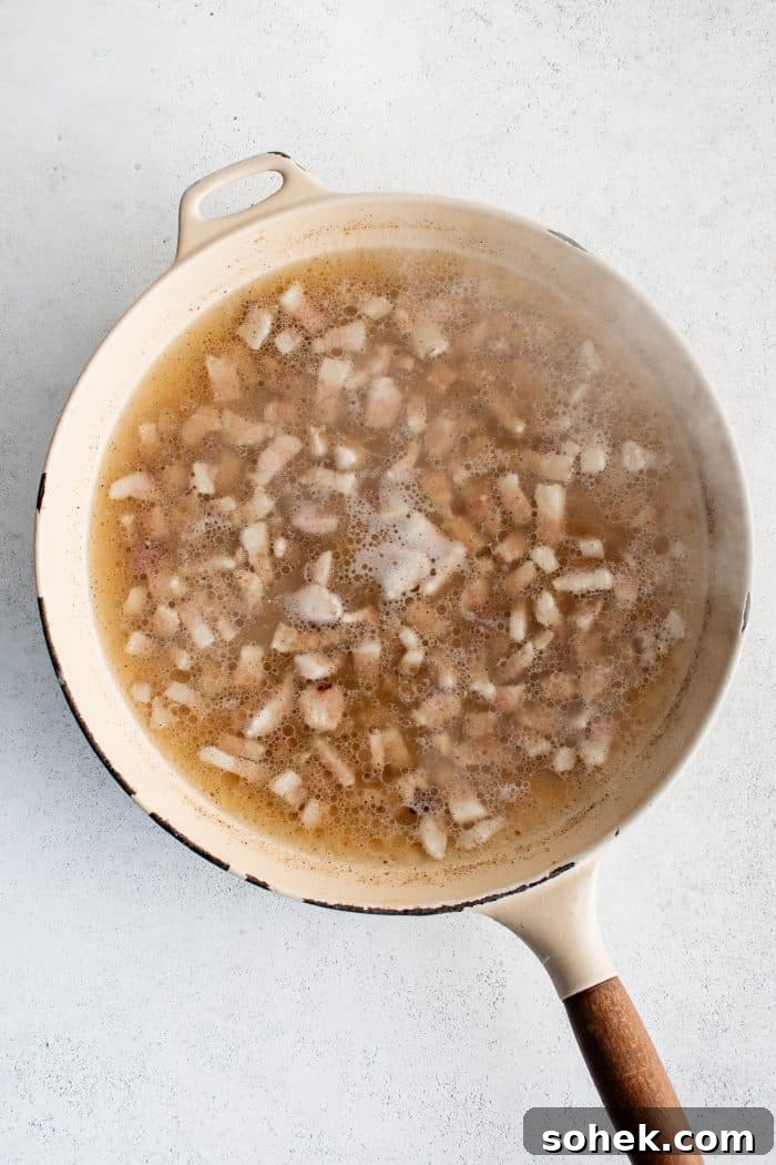 Guanciale, rendered pork fat, and pasta water simmering in large pan.