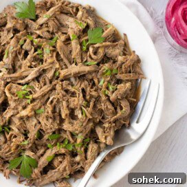 Slow Cooker Shredded Beef Recipe for Sandwiches and Tacos 10 A bowl of rich brown shredded beef ready to go for tacos, wrap, and more.