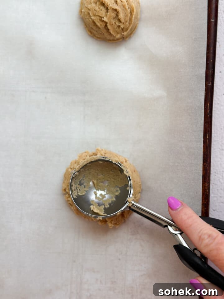 pushing the scoop into the dough to make an indention.