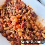 Five Bean Baked Beans up close on a wooden serving spoon