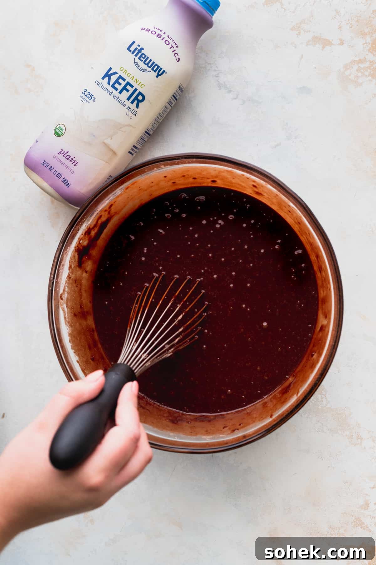 Mixing cake batter in a glass bowl.