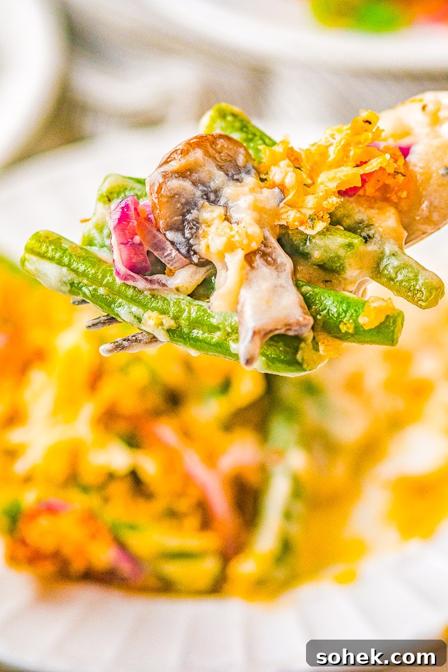 Classic Green Bean Casserole Recipe for Holiday Dinner 11 A fork holding a bite of green bean casserole.
