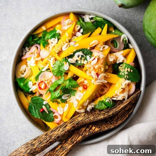 Spicy Thai Green Mango Salad (Yam Ma Muang) — Tangy Mango Thai Salad 12 A serving bowl with spicy Thai green mango salad and bamboo serving spoons.