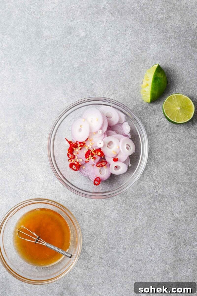 Spicy Thai Green Mango Salad (Yam Ma Muang) — Tangy Mango Thai Salad 5 A bowl with fish sauce, lime juice and palm sugar and another bowl with thinly sliced shallots and red chillies to make the spicy Thai salad dressing.