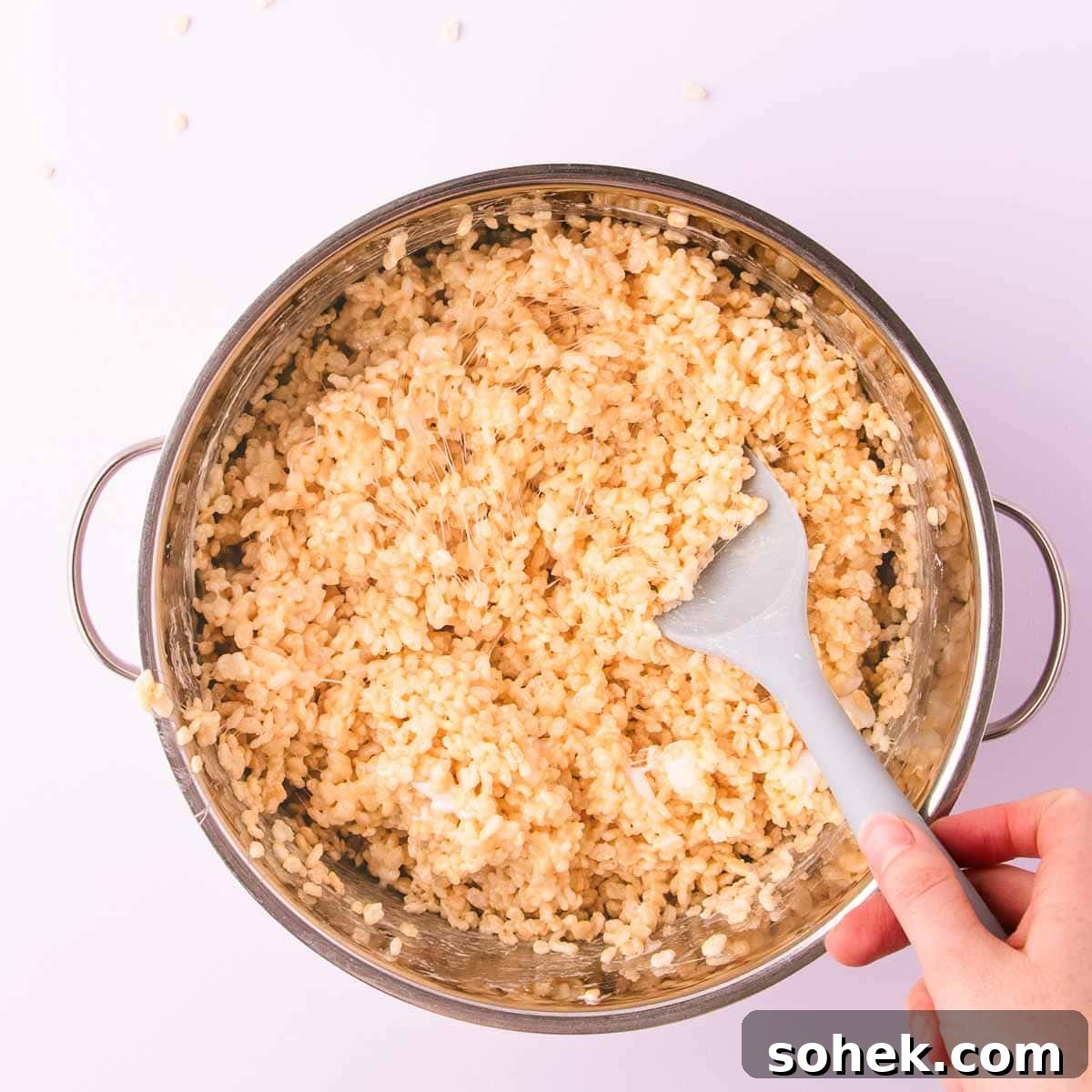 Gluten-Free Rice Krispie Treats Recipe — Crispy & Chewy Bars 8 The rice crispy cereal being stirred into the sticky marshmallow mixture.