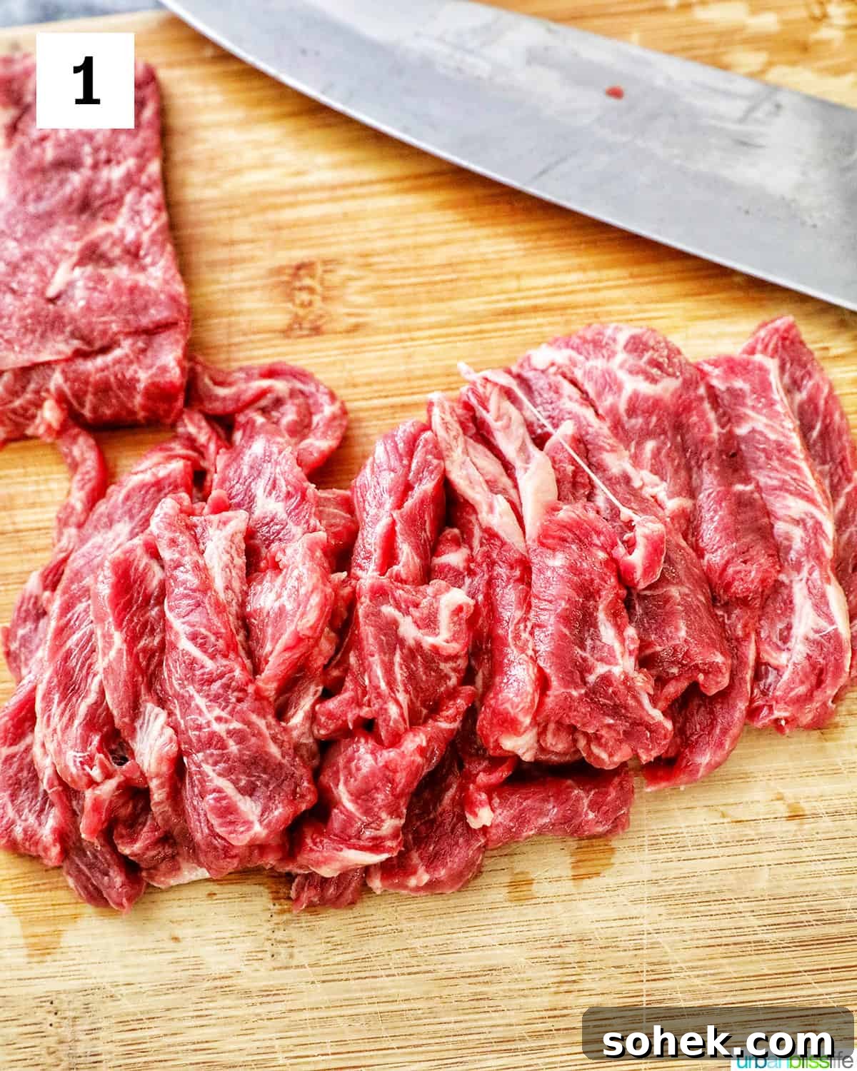 steak sliced thinly on a cutting board with a knife.