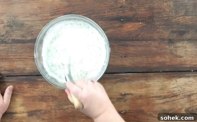Copycat Restaurant-Style Ranch Dressing Recipe for Flavorful Salads 7 Whisking the mayonnaise, milk and ranch dressing together in a glass bowl