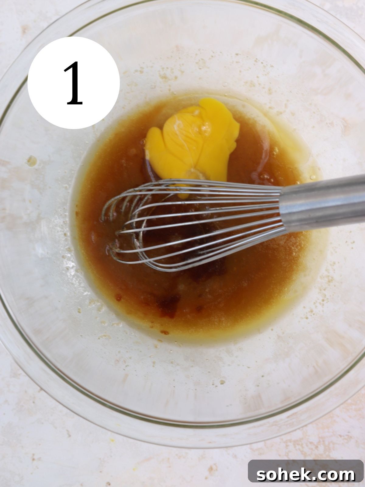 Whisking egg into melted butter and sugar