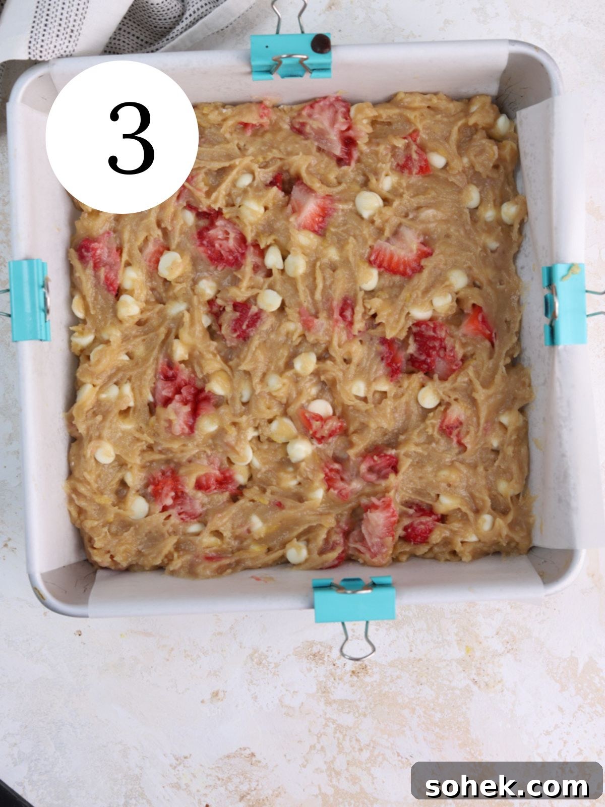 Strawberry blondie batter spread in a pan